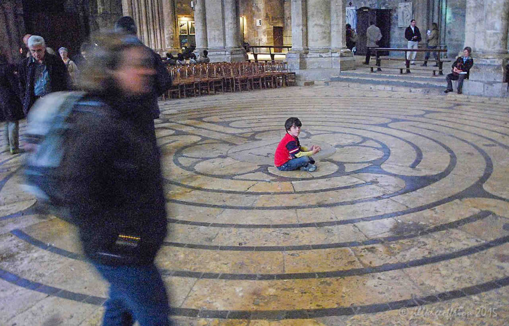 Boy sits in the middle of the Chartres Labyrinth by Jill K H Geoffrion